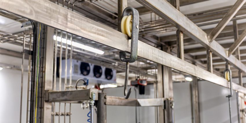 Meat hook and pulley hanging from industrial ceiling rail